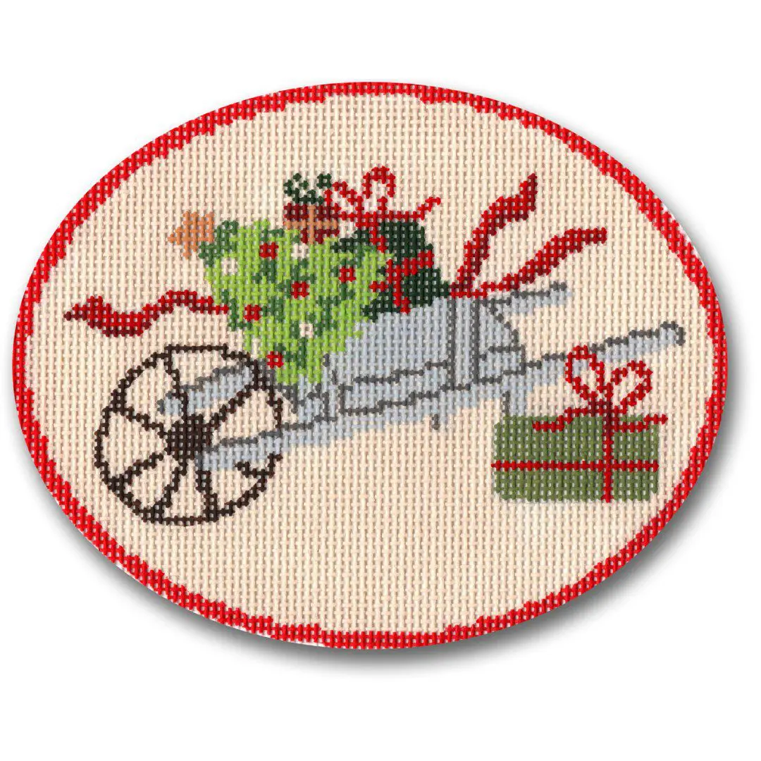 A cross stitch picture of a wheelbarrow with Christmas presents designed by Cecilia Ohm.