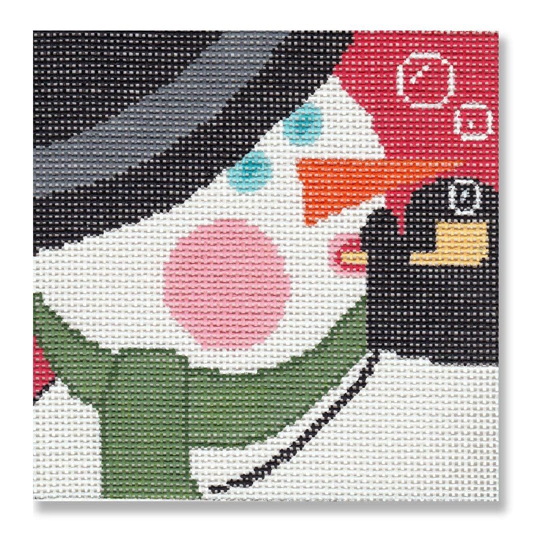 A snowman wearing a hat and scarf on a cross stitch canvas designed by Cecilia Ohm Eriksen.