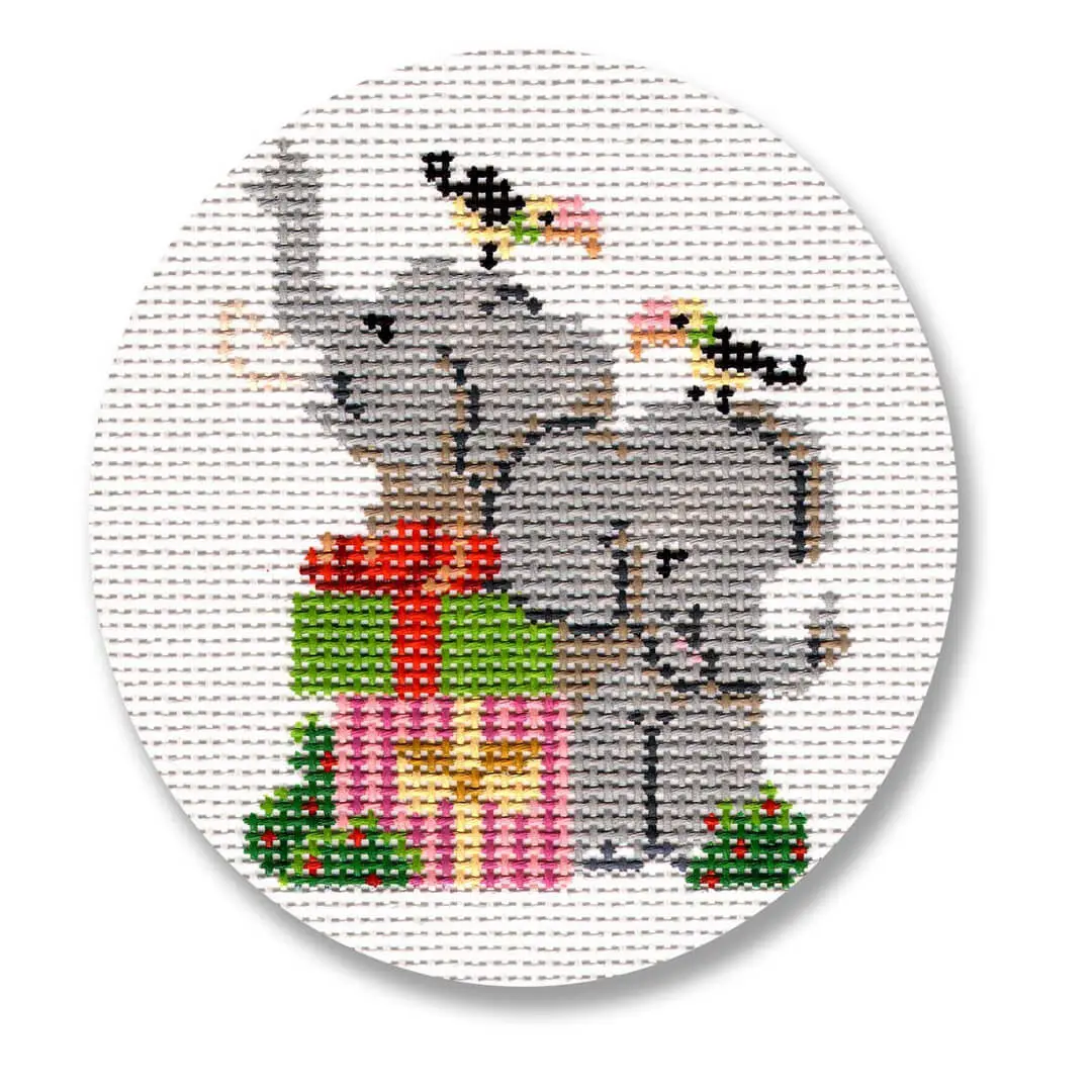 A cross stitch pattern featuring adorable elephants holding a gift box, designed by Cecilia Ohm Eriksen.