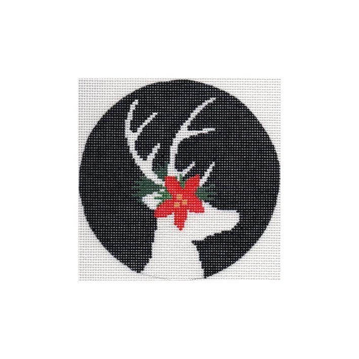 A cross stitch pattern of a reindeer with red poinsettias designed by Cecilia Ohm Eriksen.