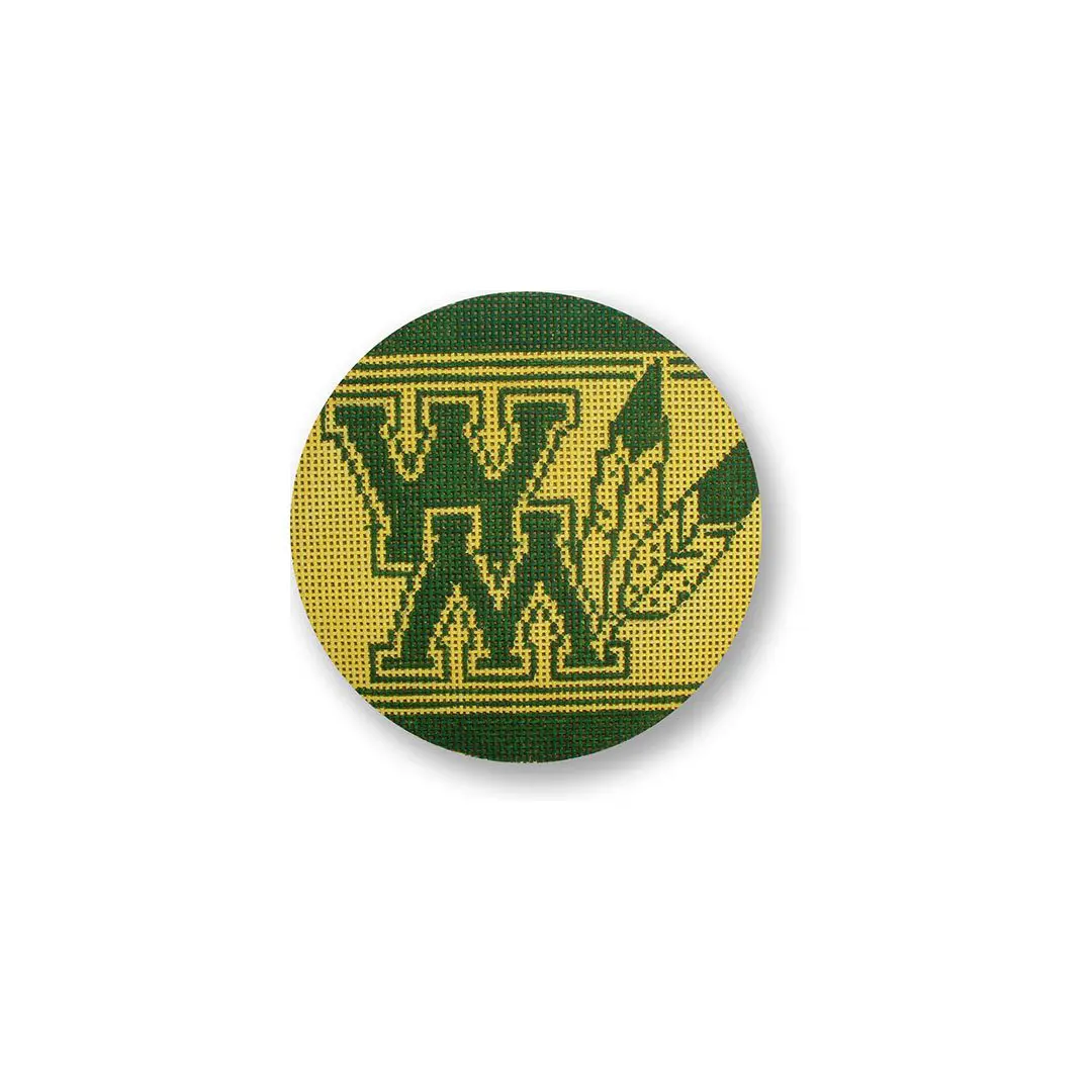 A green and yellow button with the word wm on it, designed by Cecilia Ohm.