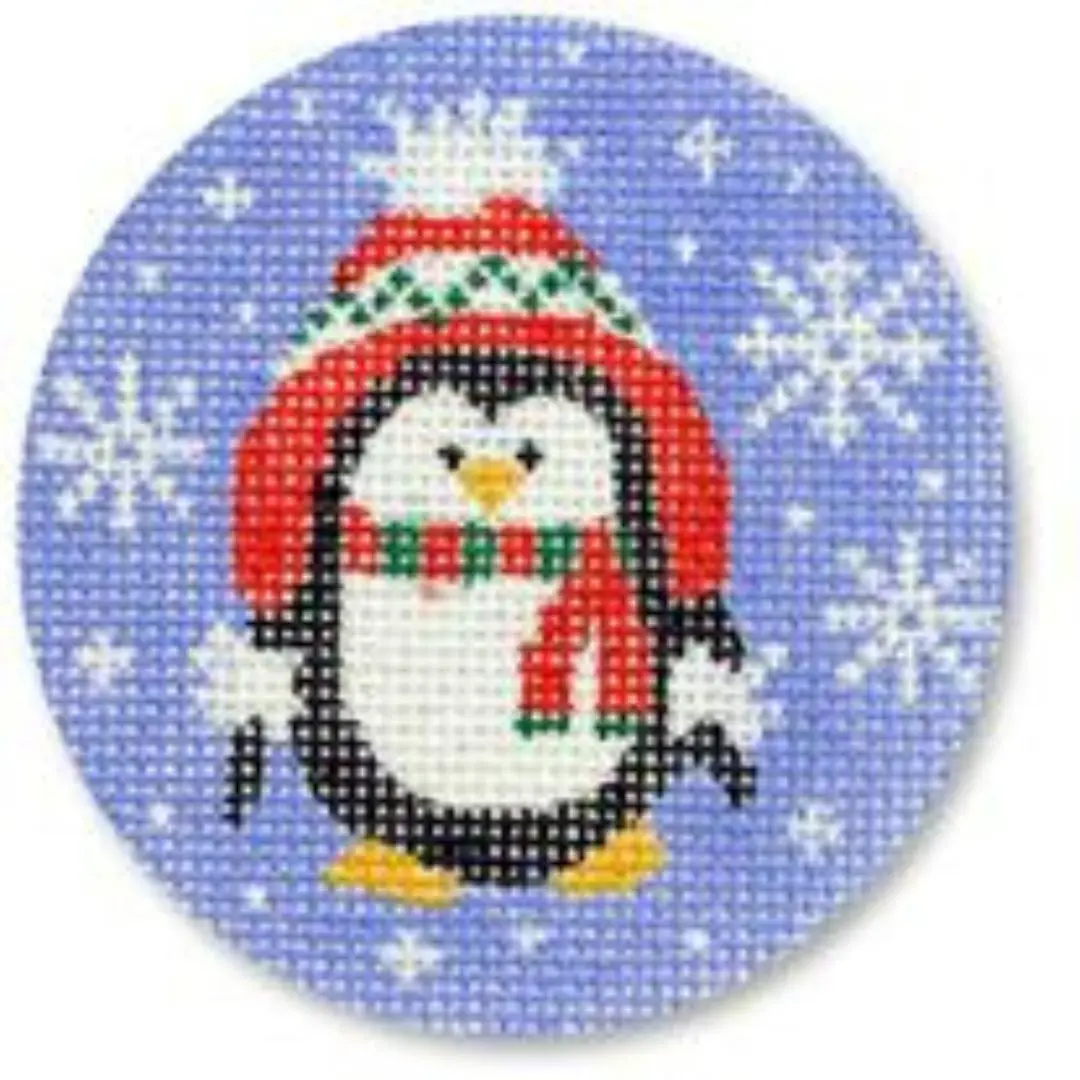 A cross stitch kit with a penguin wearing a hat and scarf designed by Cecilia Ohm.