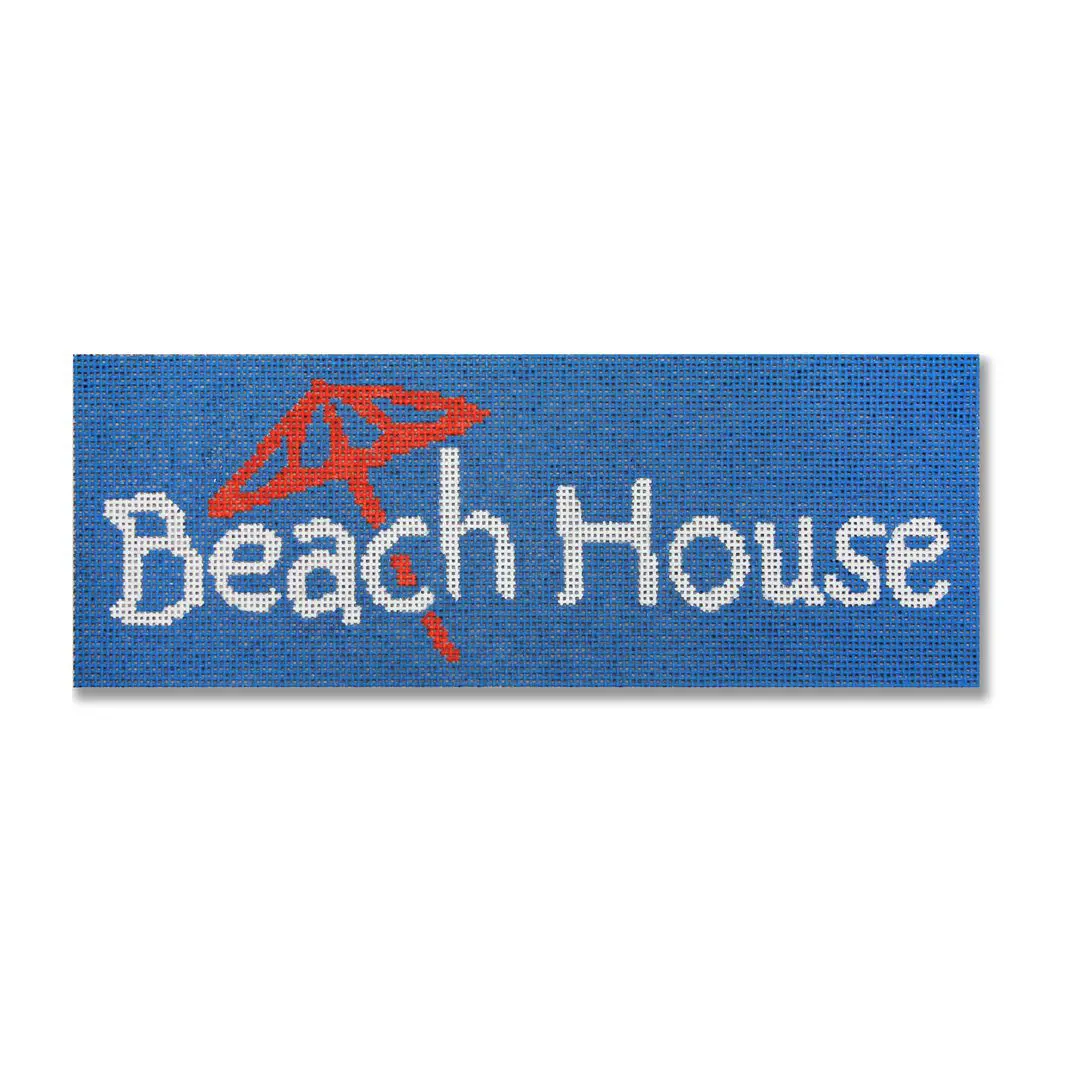 A blue rug with the word "beach house" on it designed by Cecilia Ohm.