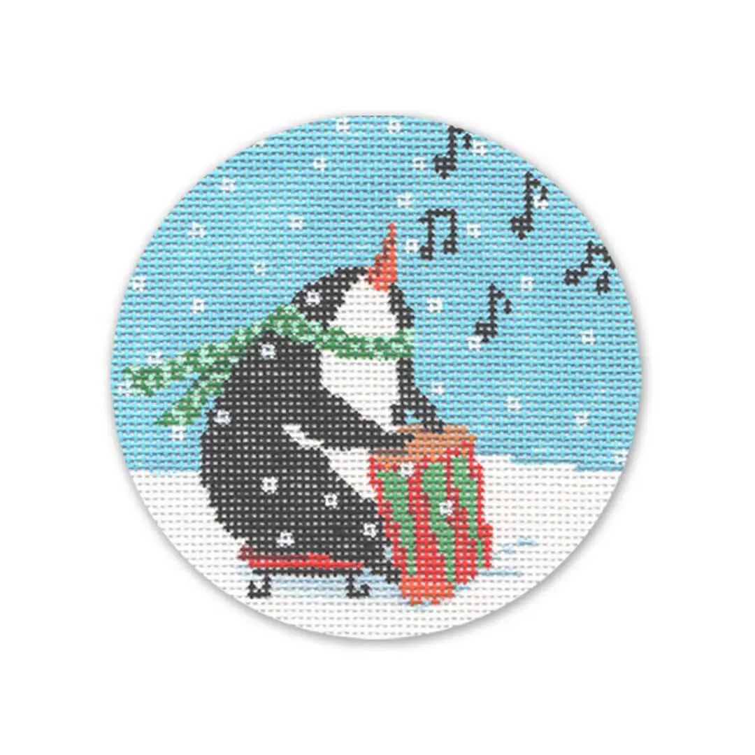 A cross stitch pattern of a penguin playing a drum designed by Cecilia Ohm Eriksen.
