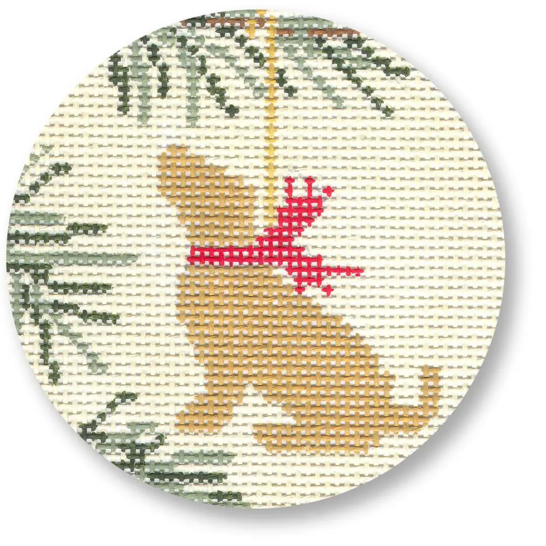 A cross stitch pattern of a dog hanging from a Christmas tree designed by Cecilia Ohm Eriksen.