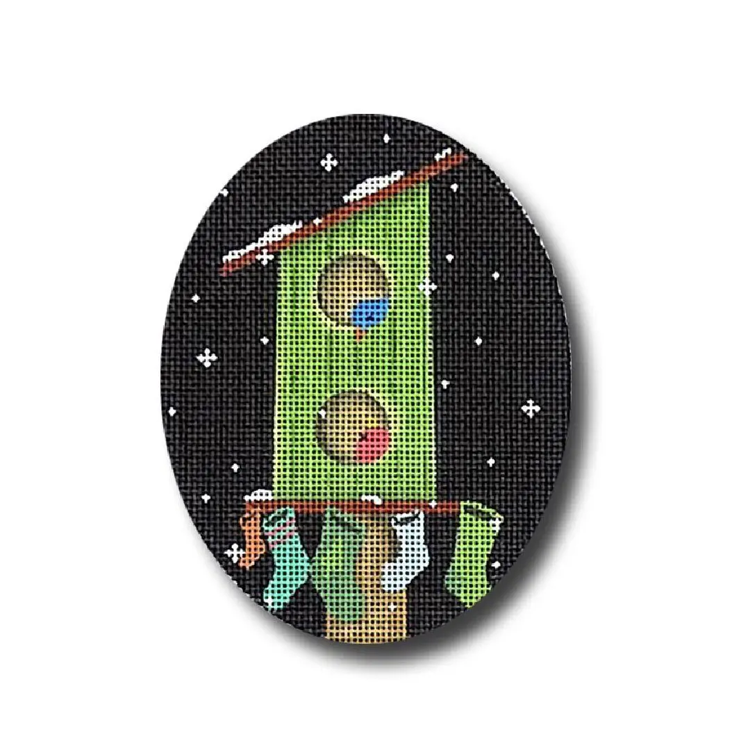 A cross stitch picture of a birdhouse on a black background by Cecilia Ohm Eriksen.