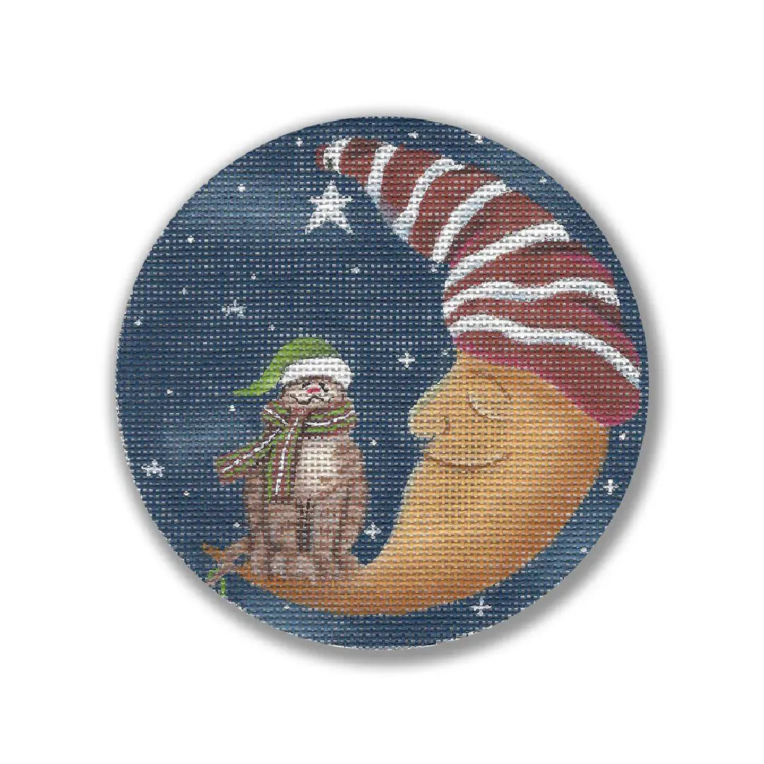 A cross stitch picture of a santa hat and a sock monkey on the moon, created by Cecilia Ohm Eriksen.