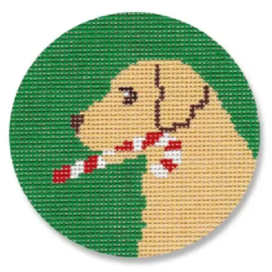 A cross stitch picture of a golden retriever holding a candy cane, designed by Cecilia Eriksen.