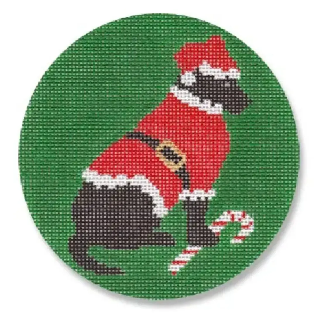 A black labrador wearing a festive Santa Claus hat poses on a vibrant green background.