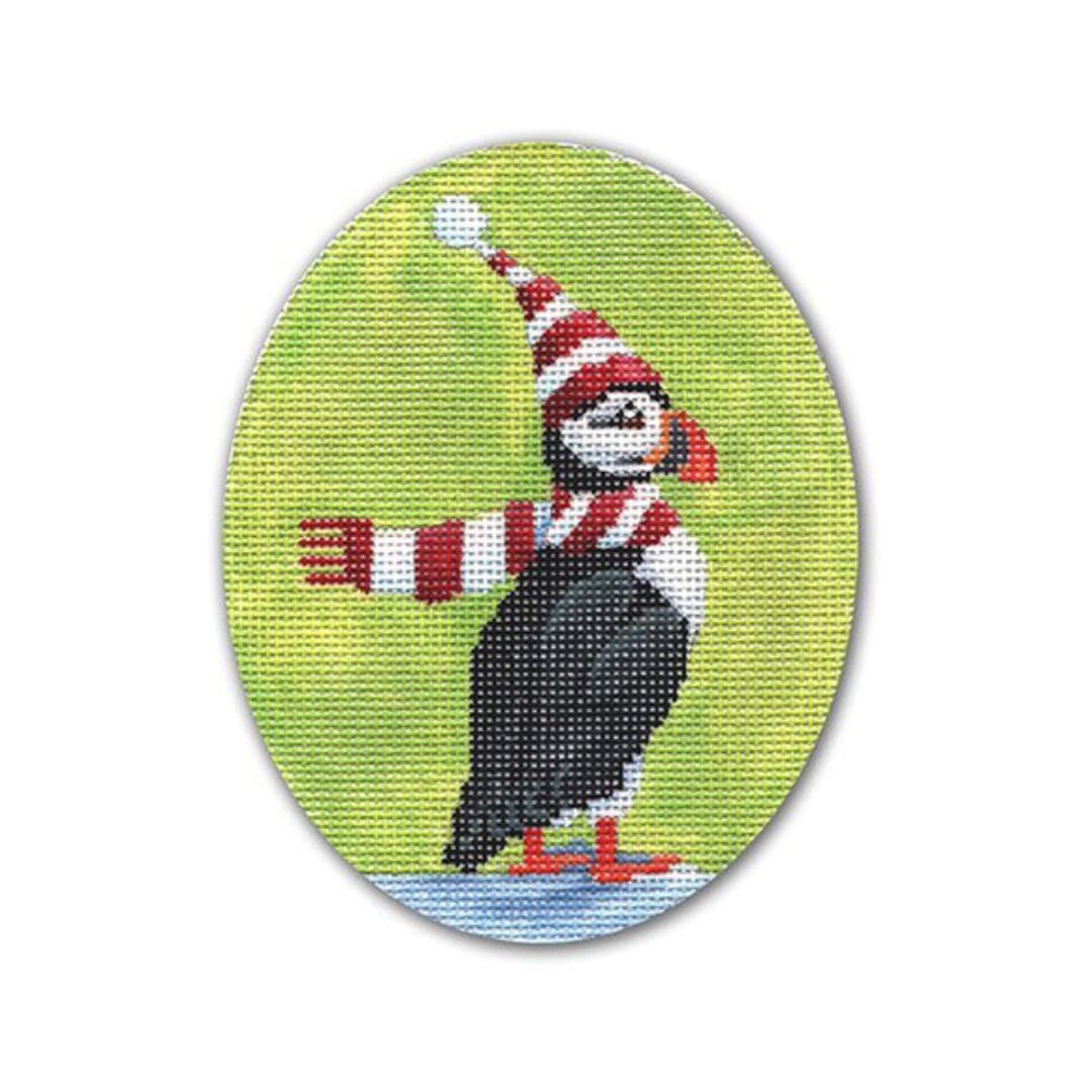A cross stitch picture of a puffin wearing a hat and scarf by Cecilia Ohm Eriksen.