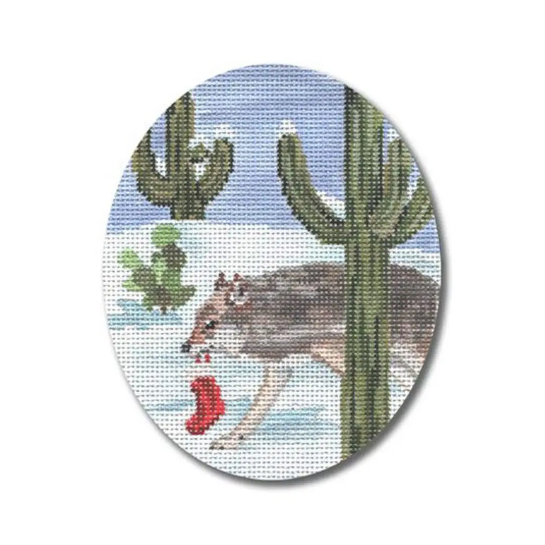 A cross stitch picture of a deer in the snow with cactus created by Cecilia.
