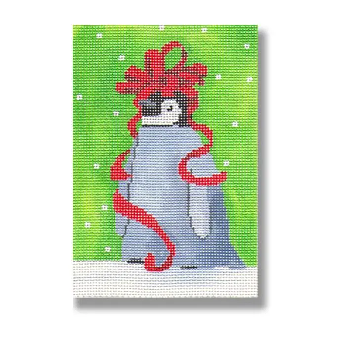 A cross stitch picture of a penguin with a red bow.