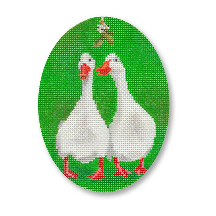 A cross stitch picture of two geese on a green background.