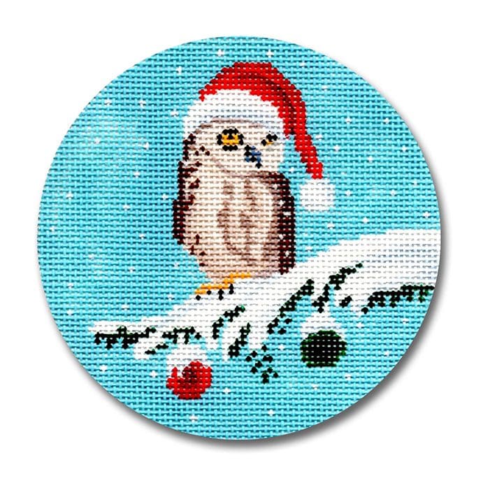 An owl in a santa hat sitting on a christmas tree.