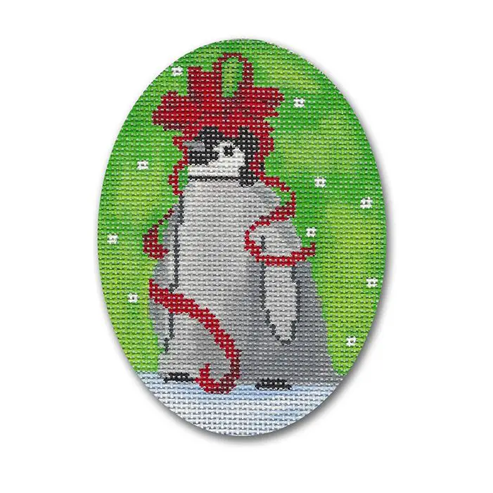A cross stitch picture of a penguin with a red bow.