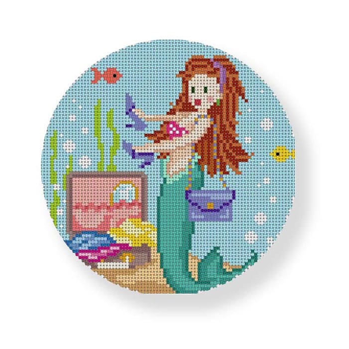 A cross stitch pattern of a mermaid with a purse designed by Cecilia Ohm Eriksen.