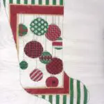 A christmas stocking with red, green and white ornaments.